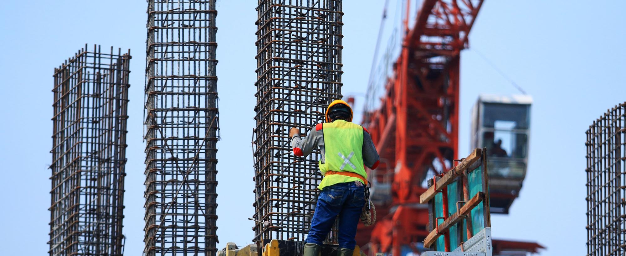 Construction worker on crane in blue sky